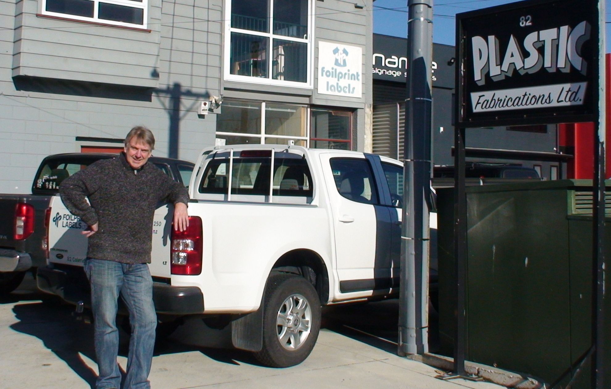 Trevor leaning on a car outside the workshop